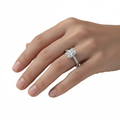moissanite ring on a hand against a white background